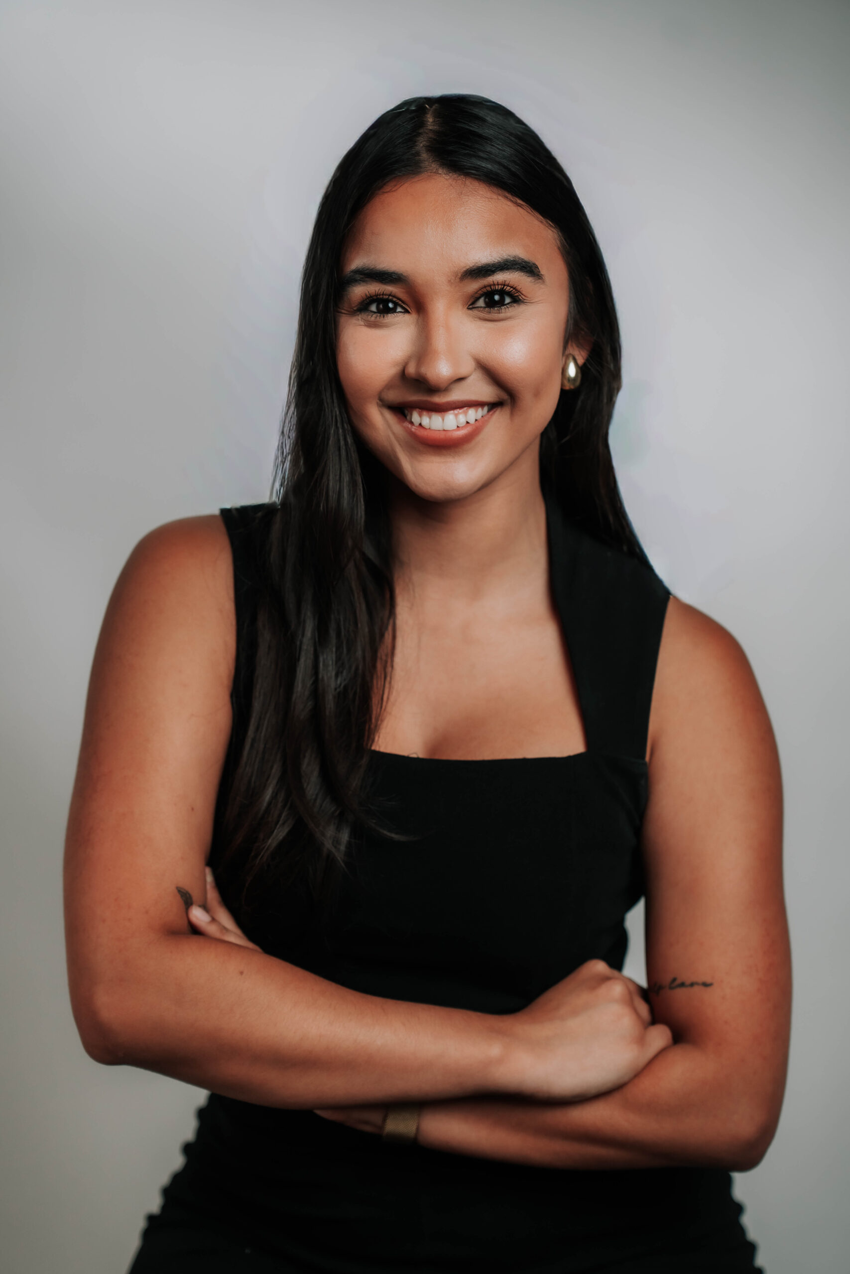 A poised professional headshot of Christina Gunn, Business Development for Advine Agency. Christina's friendly yet confident demeanor, with her arms crossed, projects strong client relationships and growth-oriented strategies.