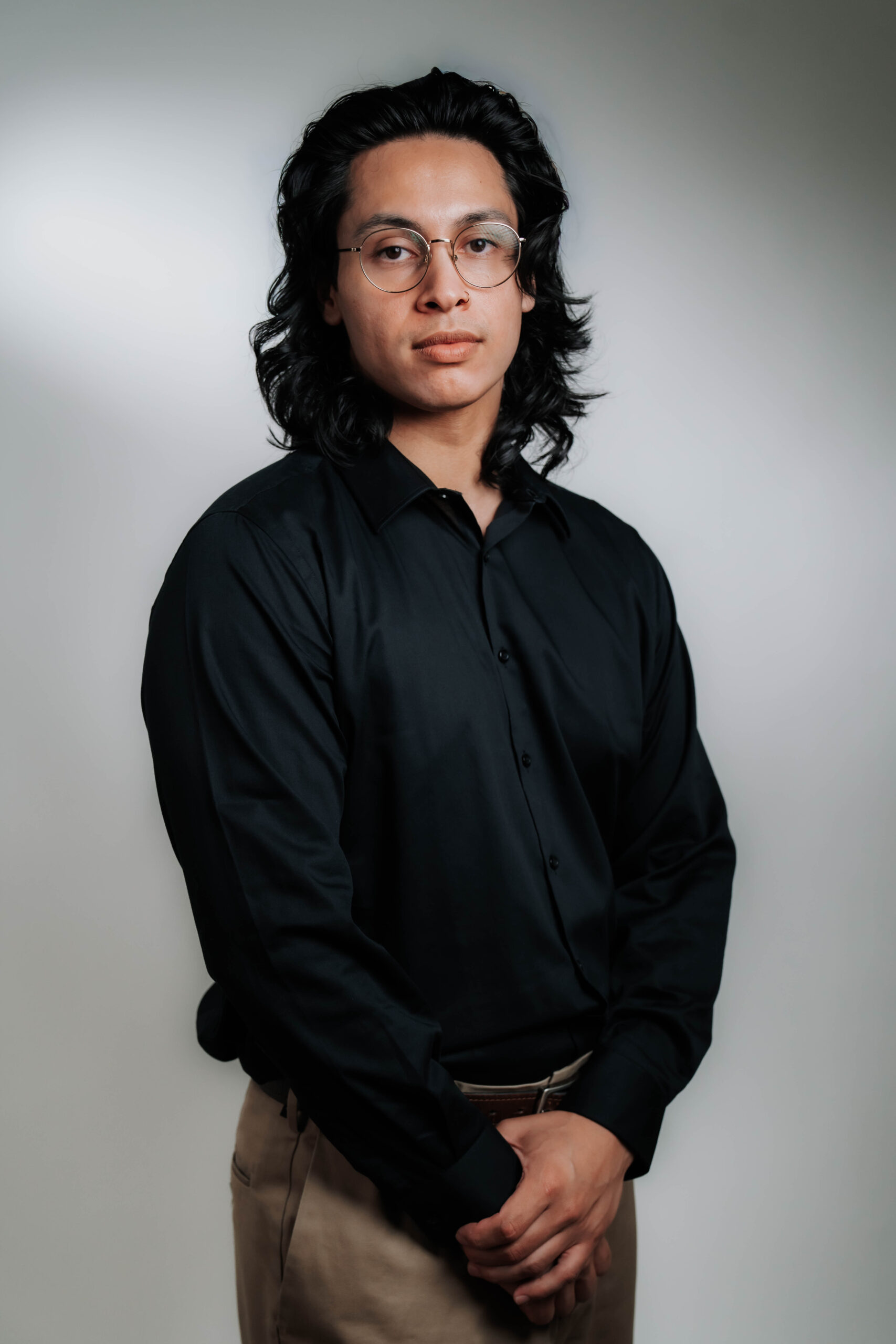 A focused professional headshot of Cameron Dominguez, Multimedia Producer for Advine Agency. Cameron's thoughtful expression and professional demeanor in a black collared shirt highlight his dedication and skill in producing high-quality multimedia content.