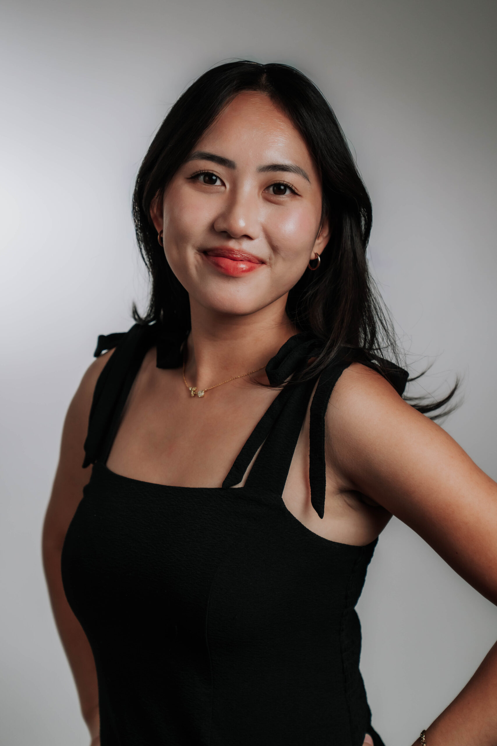 A bright professional headshot of Eriny Xiong, Social Media Coordinator at Advine Agency. Eriny's pleasant smile and fashionable top radiate professionalism and creativity, essential for impactful social media campaigns.