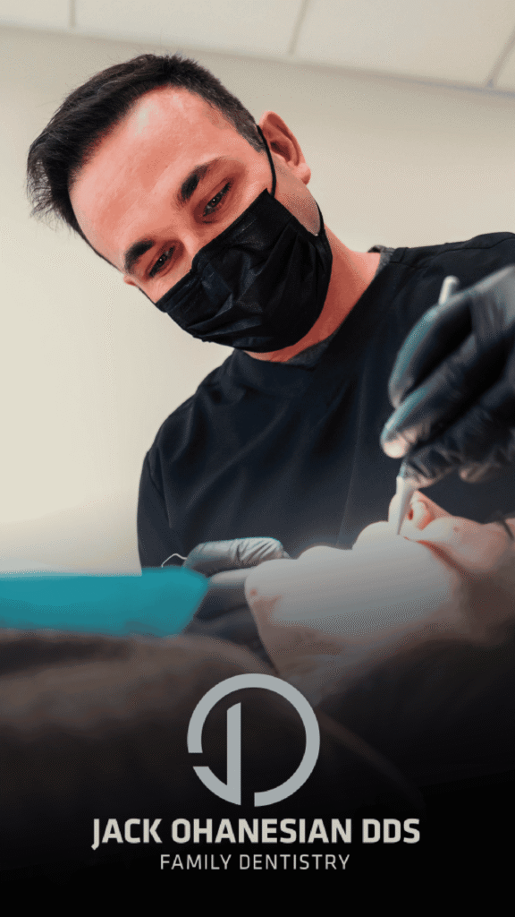 Jack Ohanesian Advine's clean, focused commercial photography shows Jack Ohanesian, DDS (Family Dentistry) operating on a patient while wearing a black mask and gloves, emphasizing the professional, caring environment of the practice.