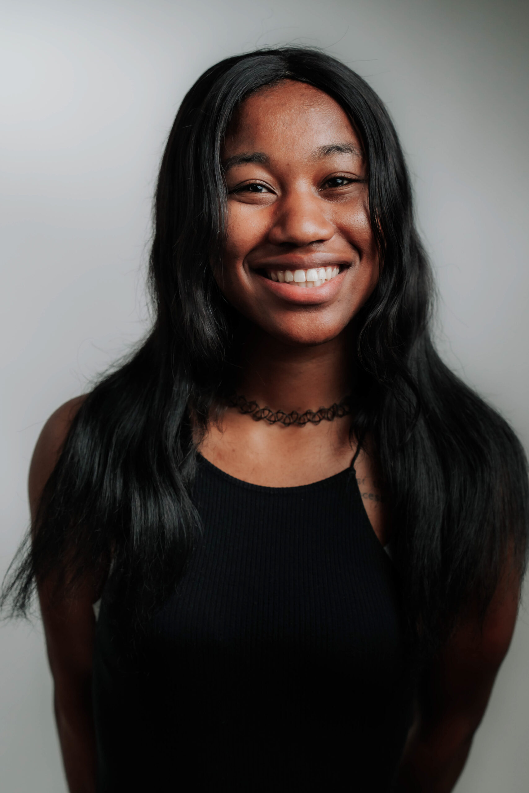 A cheerful professional headshot of Elisabeth Lemmons, Social Media Coordinator & Producer at Advine Agency. Elisabeth's radiant smile and unique style, showcase her vibrant personality and expertise in social media engagement.