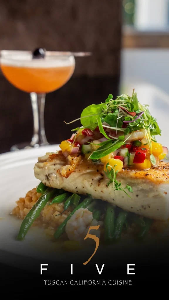 Advine's photography captures a perfectly plated dish of Tuscan California Cuisine from FIVE Restaurant, featuring grilled fish topped with salsa, green beans, and a side of rice, with a stylish cocktail in the soft-focus background.
